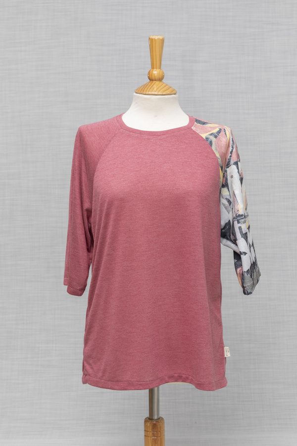 CAMISETA ROSA CON UNA MANGA CORTA DIFERENTE PUESTA EN MANIQUI